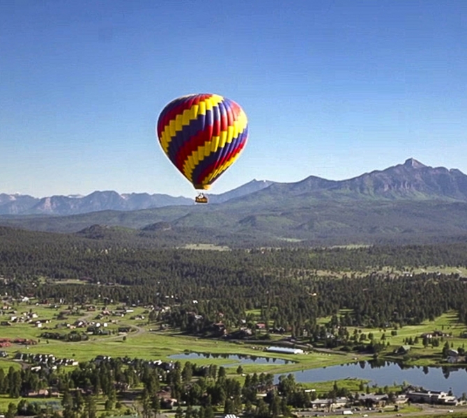 A wide shot of hot air balloon rising in to the sky in Pagosa Springs
