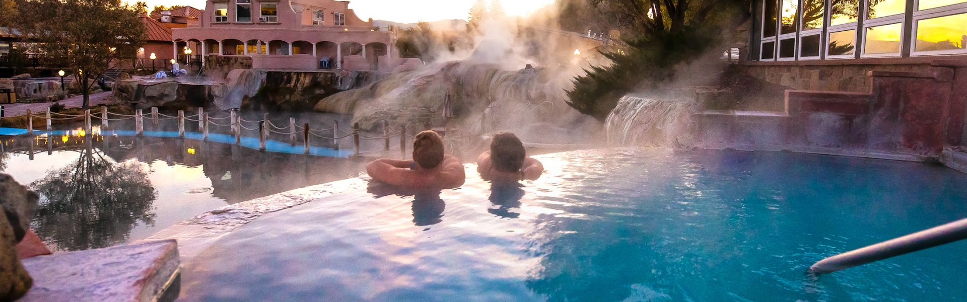 A rearview of a couple soaking in the hot spring pool